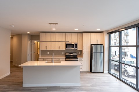 a kitchen with a large island and a stainless steel refrigerator