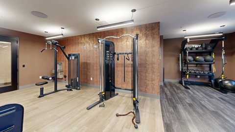 A gym with a variety of equipment including a squat rack, a leg press machine, and a bench press at The Standard Apartments, Allentown