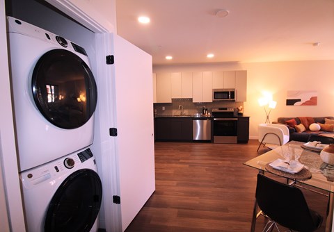 A modern kitchen with a washing machine built into the cabinetry.