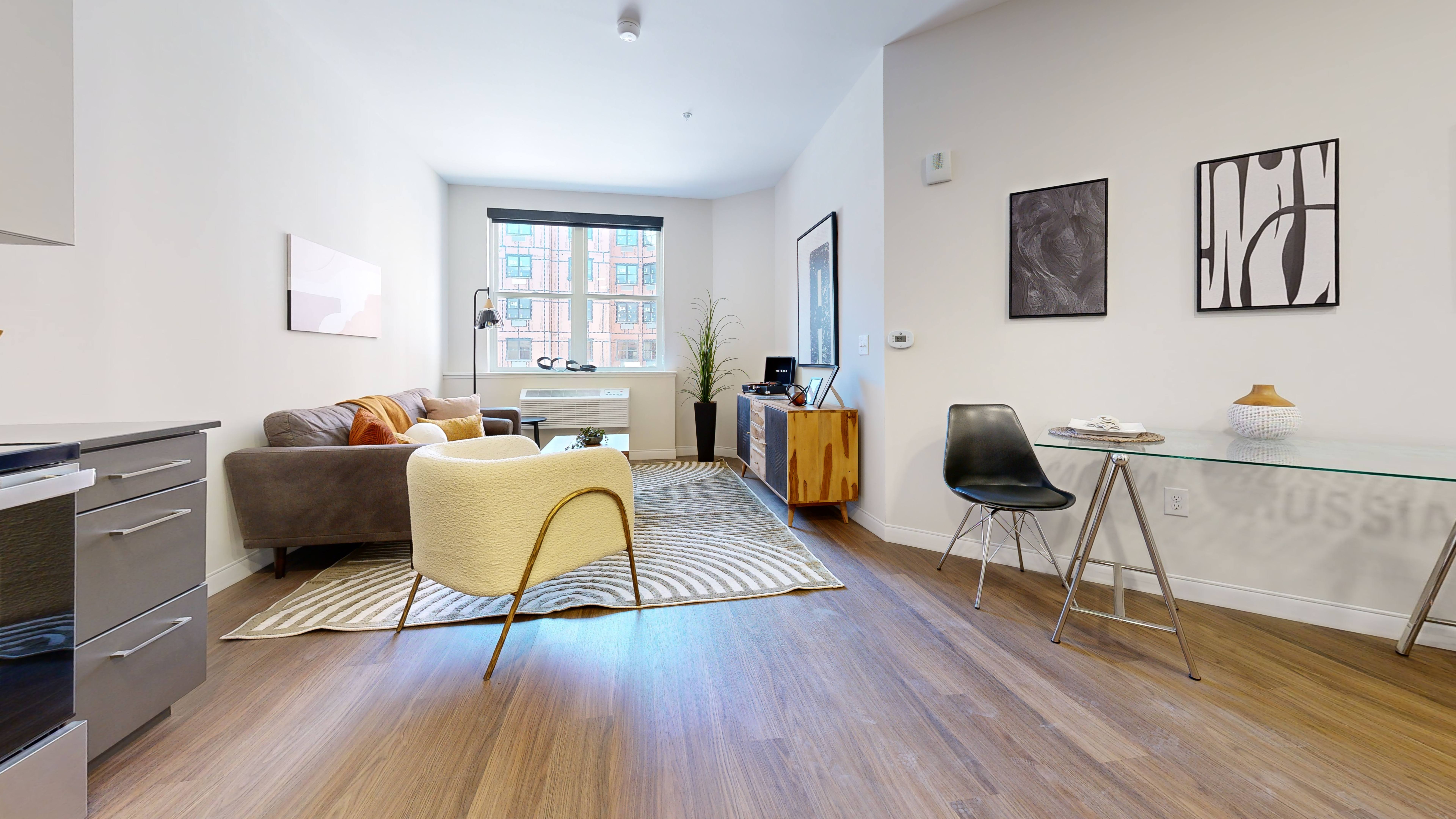 A living room with a yellow chair and a brown couch.