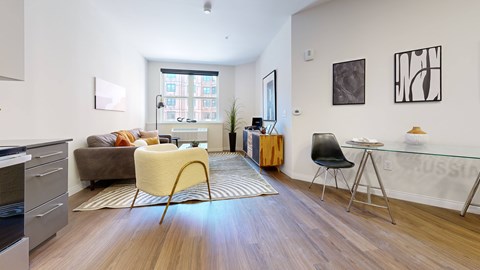 A living room with a yellow chair and a brown couch.
