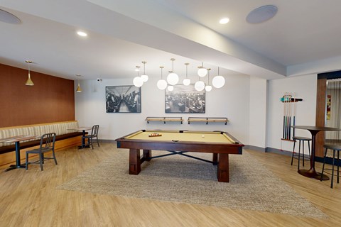 A pool table is in the middle of a room with a bench and chairs at The Standard Apartments, Pennsylvania, 18101
