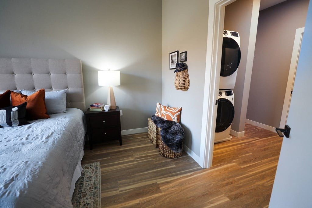 A bedroom with a bed, nightstand, and basket on the floor.