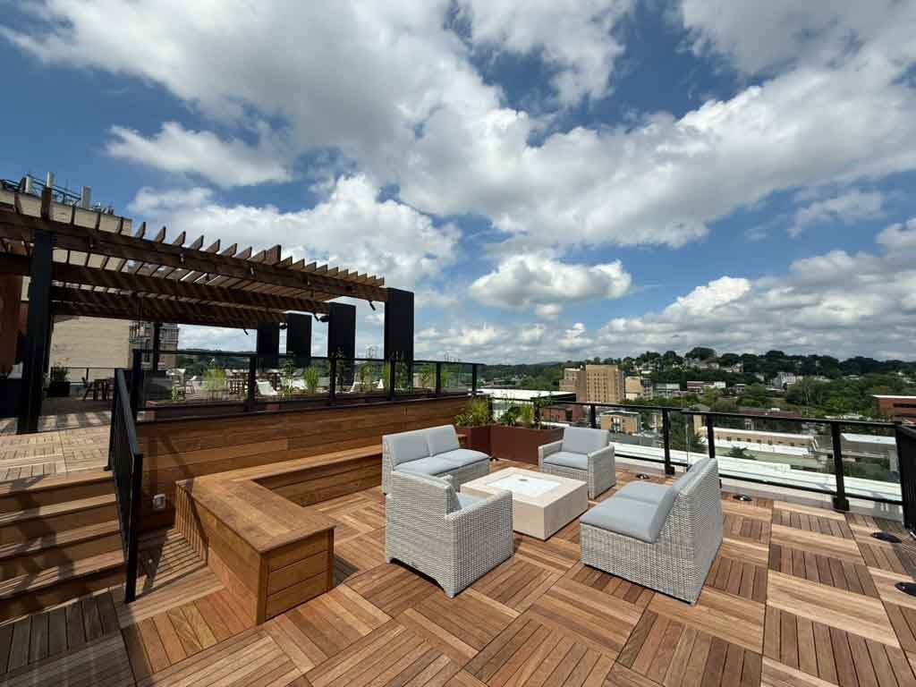 A wooden deck with white chairs and a table.