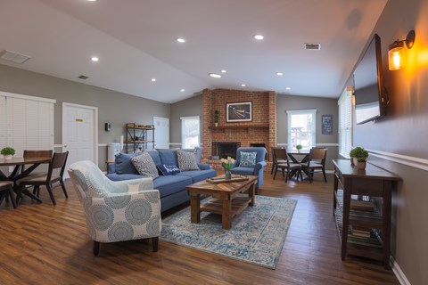 A living room with a blue couch and a fireplace.