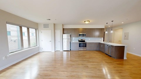 A spacious kitchen with wooden floors and modern appliances.
