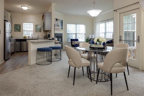 A kitchen with a table and chairs in the middle of the room.