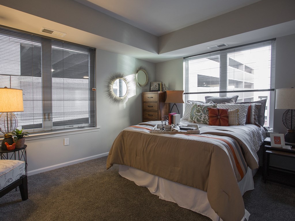 a bedroom with a bed and two windows