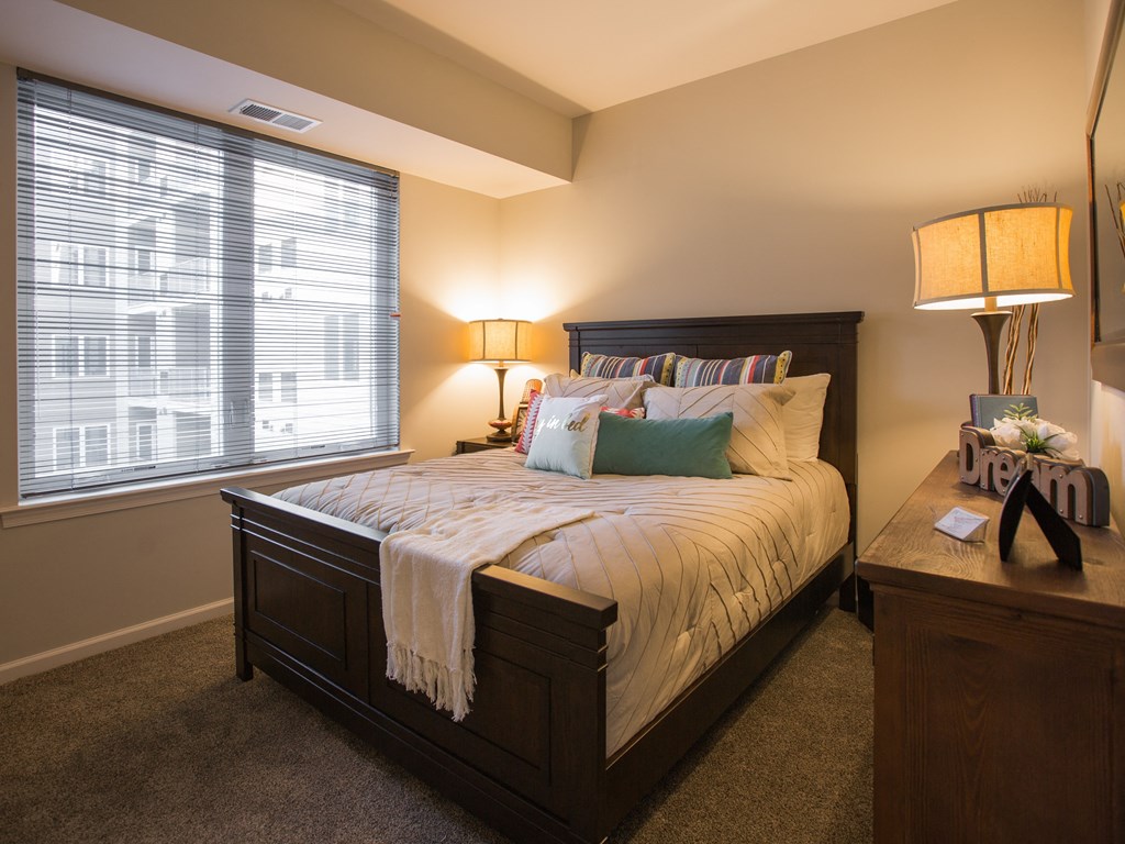 a bedroom with a large bed and a window