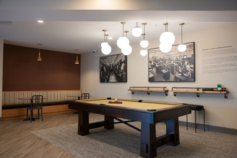 A room with a pool table and a picture on the wall.