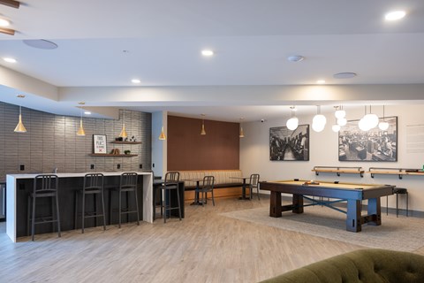 A room with a pool table and bar area.