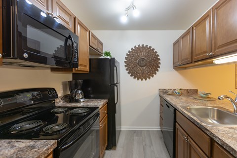 A kitchen with black appliances and wooden cabinets. at Meadows Apartments, Emmaus, 18049