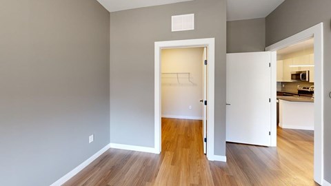 A room with a white door leading to a kitchen.
