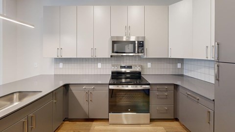 A modern kitchen with stainless steel appliances and white cabinets.