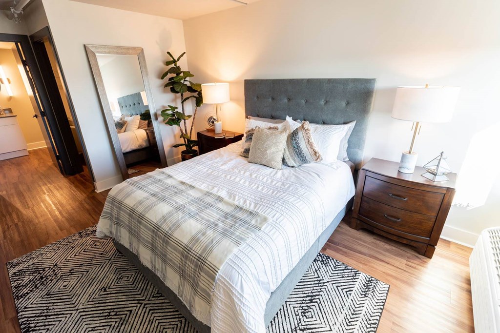 A bedroom with a large bed and a mirror on the wall at Cityplace Apartment Homes Apartments, Pennsylvania