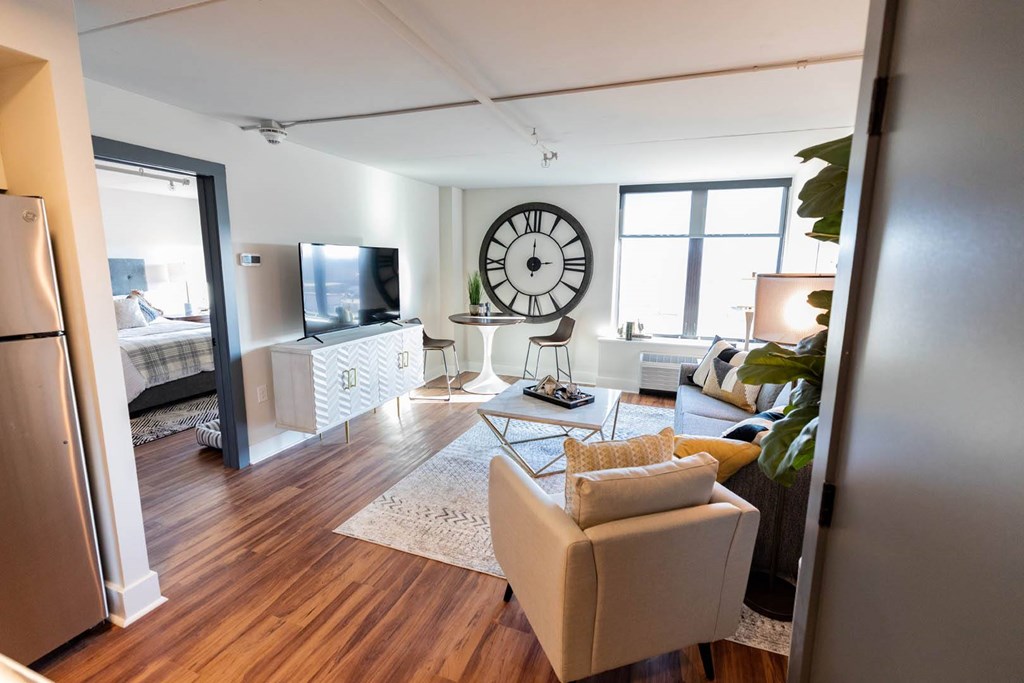 A living room with a couch, a chair, a television, and a clock on the wall at Cityplace Apartment Homes Apartments, Pennsylvania