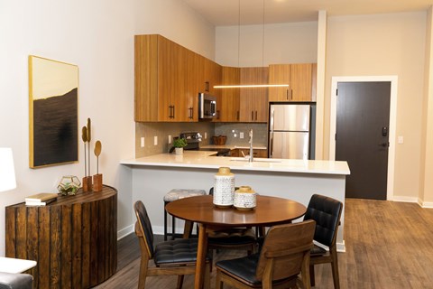 A modern kitchen with a wooden table and chairs. at The Hive Apartments, Allentown, Pennsylvania