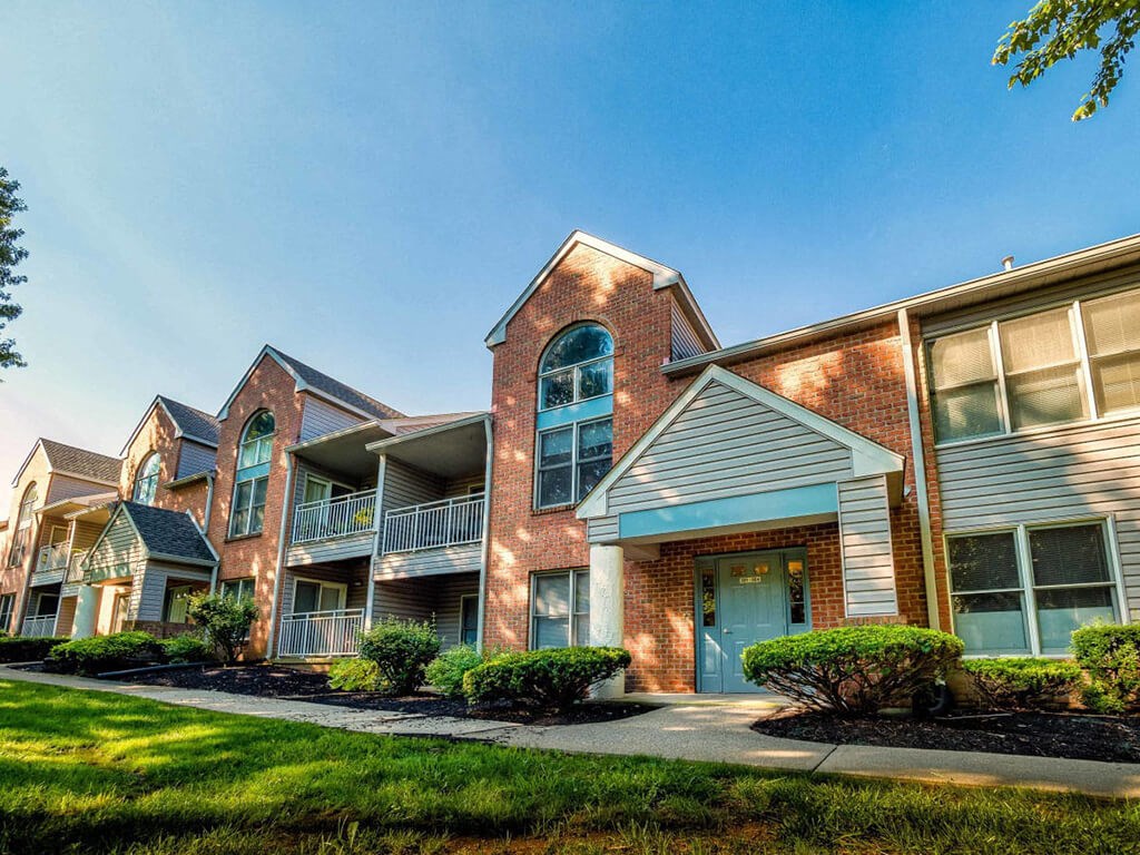 A row of townhouses with a clear blue sky above.