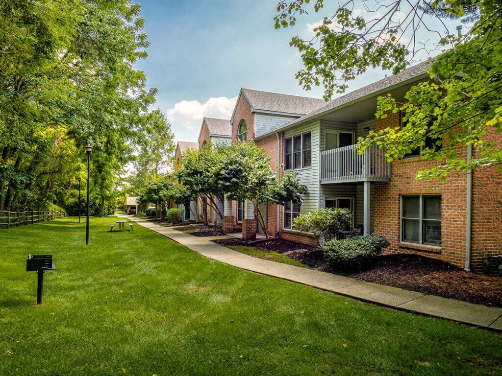 A green lawn in front of a brick building.