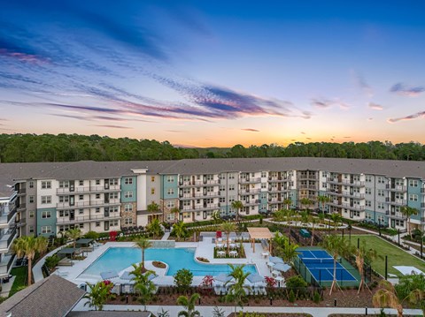 A large apartment complex with a pool and tennis court.