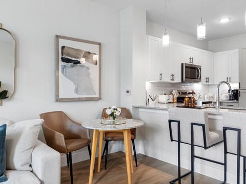A modern kitchen with a dining table and chairs.