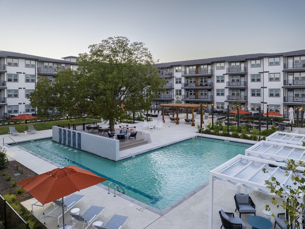 a resort-style swimming pool in the center of a senior apartment complex