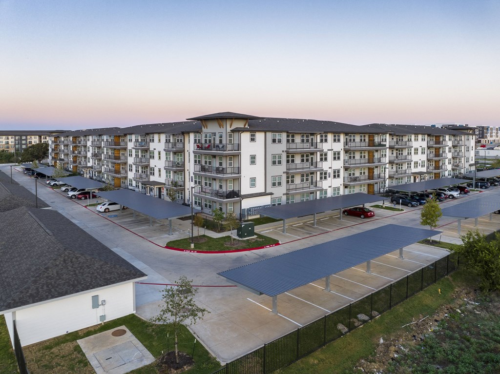 an aerial view of an apartment building with a parking lot