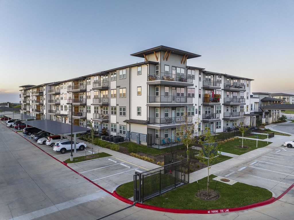 a large apartment building on the side of a parking lot