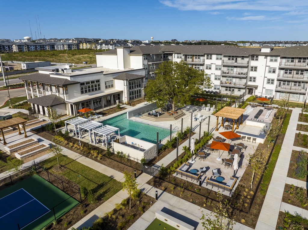 an aerial view of a building with a pool and other buildings