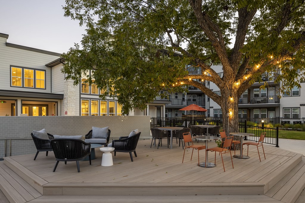 a patio with tables and chairs on a deck