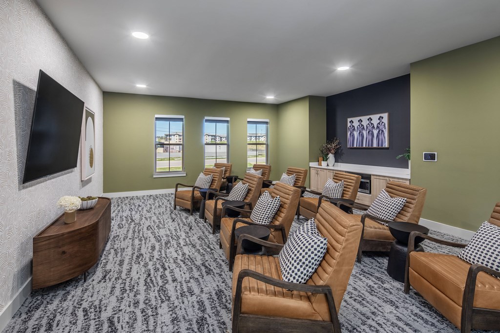 a large screening room with leather chairs and a wall mounted tv