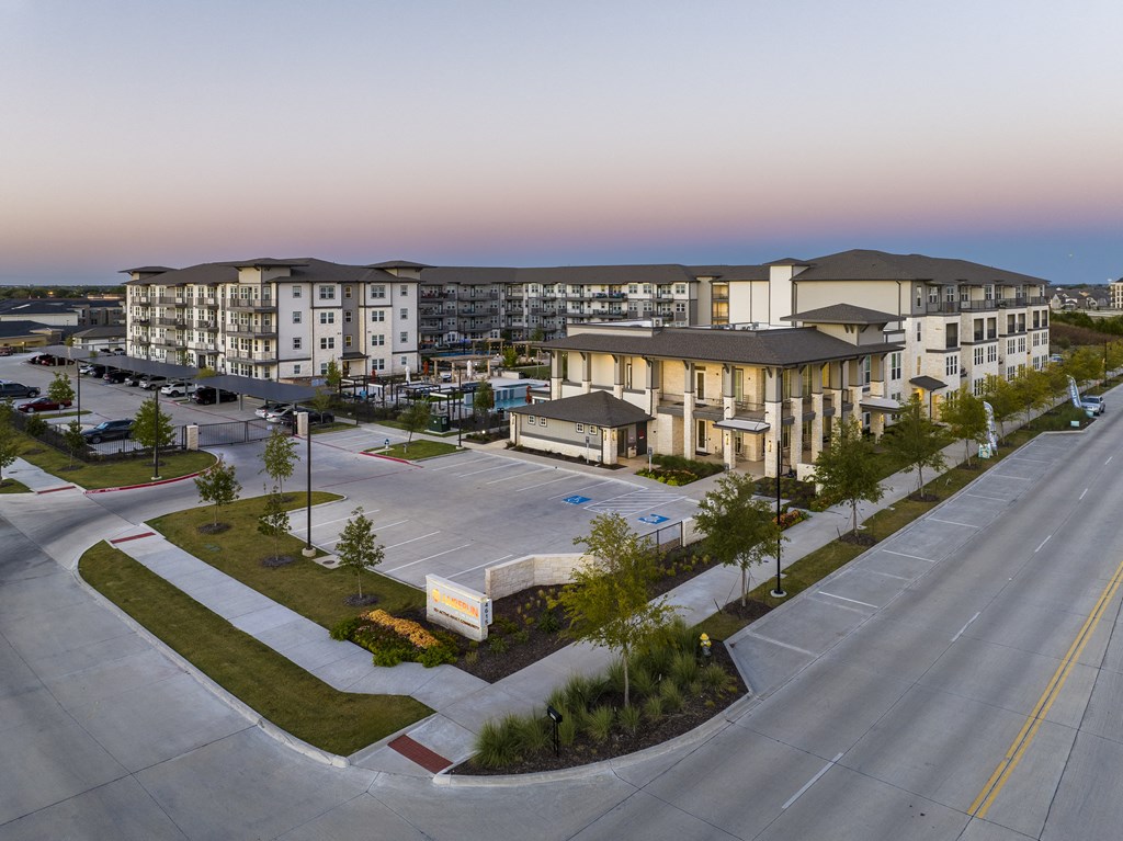 an aerial view of an empty parking lot with apartment buildings