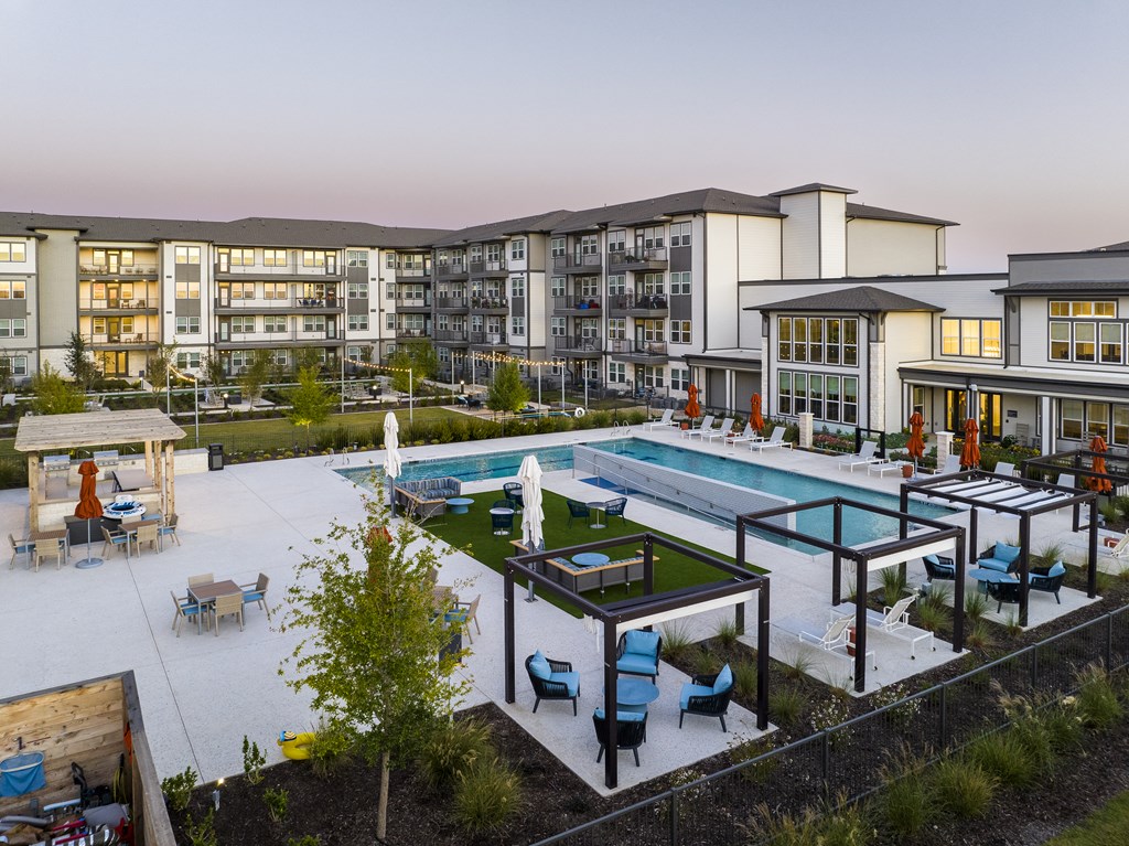 a rendering of an apartment complex with a pool and tables
