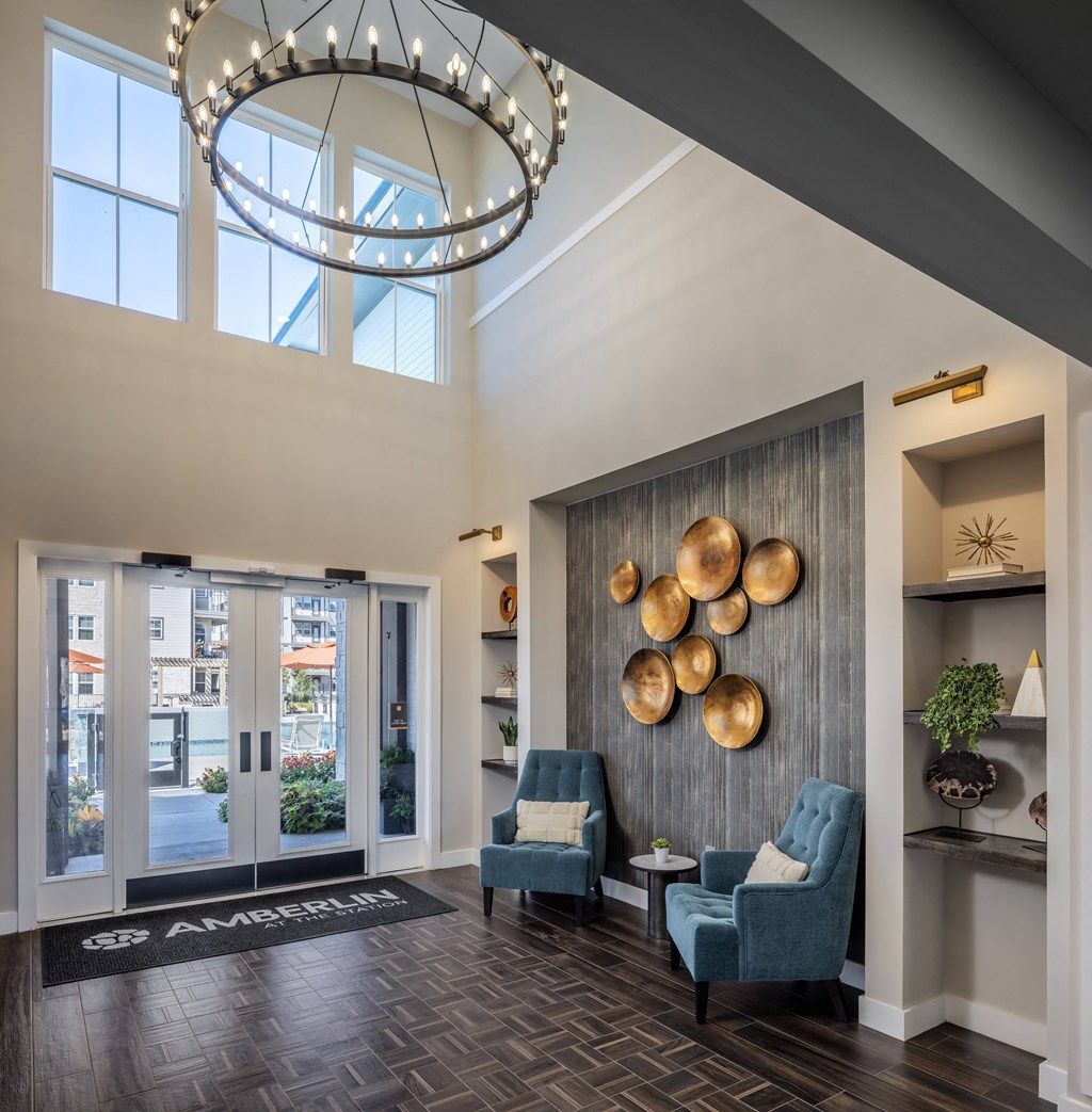 a lobby with two blue chairs and a wall with gold accents