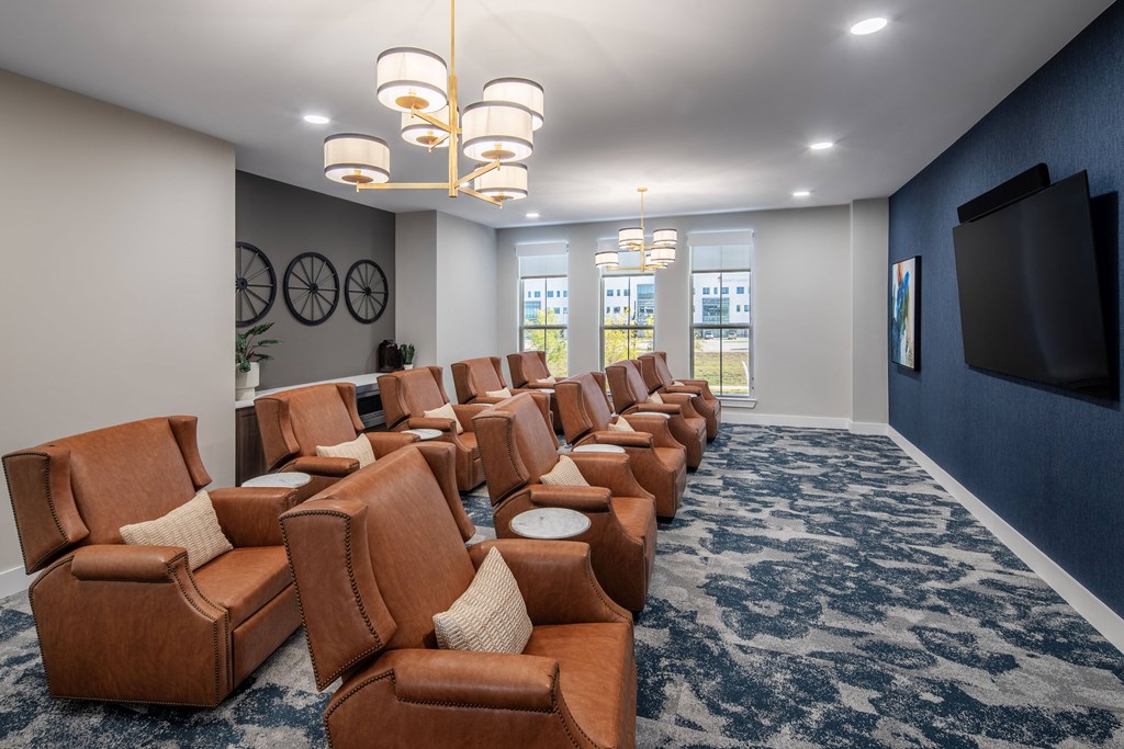 a large screening room with leather chairs and a tv