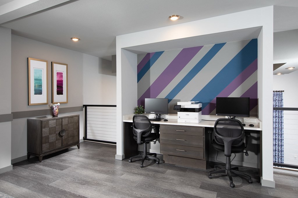 a business center with a printer and desktops at a senior apartment community