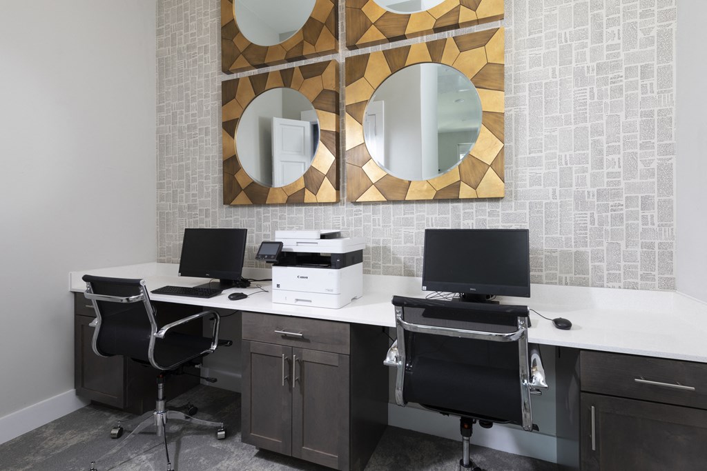 a business center with desktops and a printer at a senior apartment community