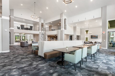 a large lobby with vaulted ceilings and sitting areas at a senior apartment community