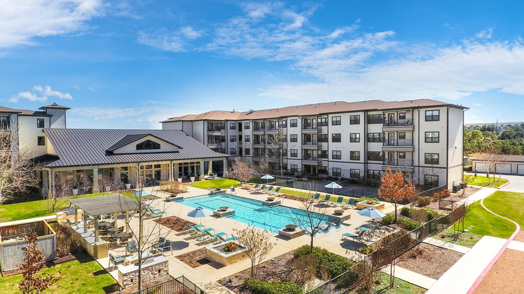 an aerial view of a swimming pool and a hotel with a courtyard