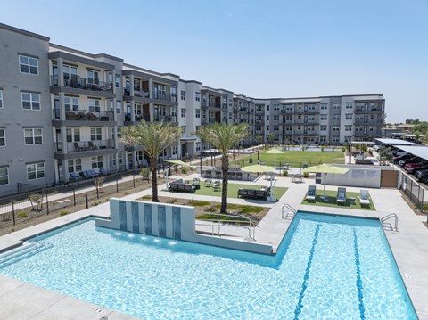 A swimming pool in front of apartment buildings.