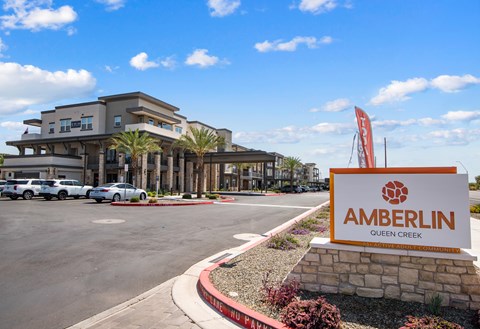 A sign for Amberlin Queen Creek stands in front of a building.