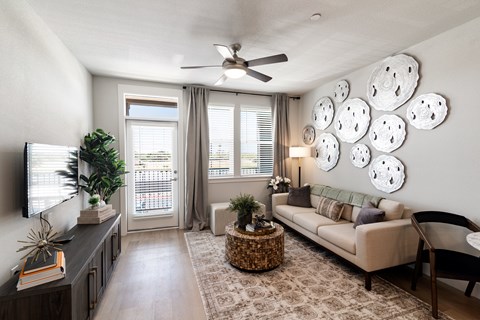 A living room with a couch, a coffee table, a television, and a plant.