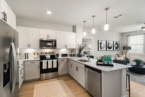 A modern kitchen with stainless steel appliances and white cabinets.