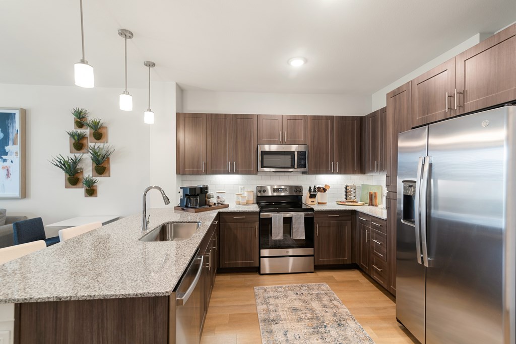 a large kitchen with stainless steel appliances and granite counter tops