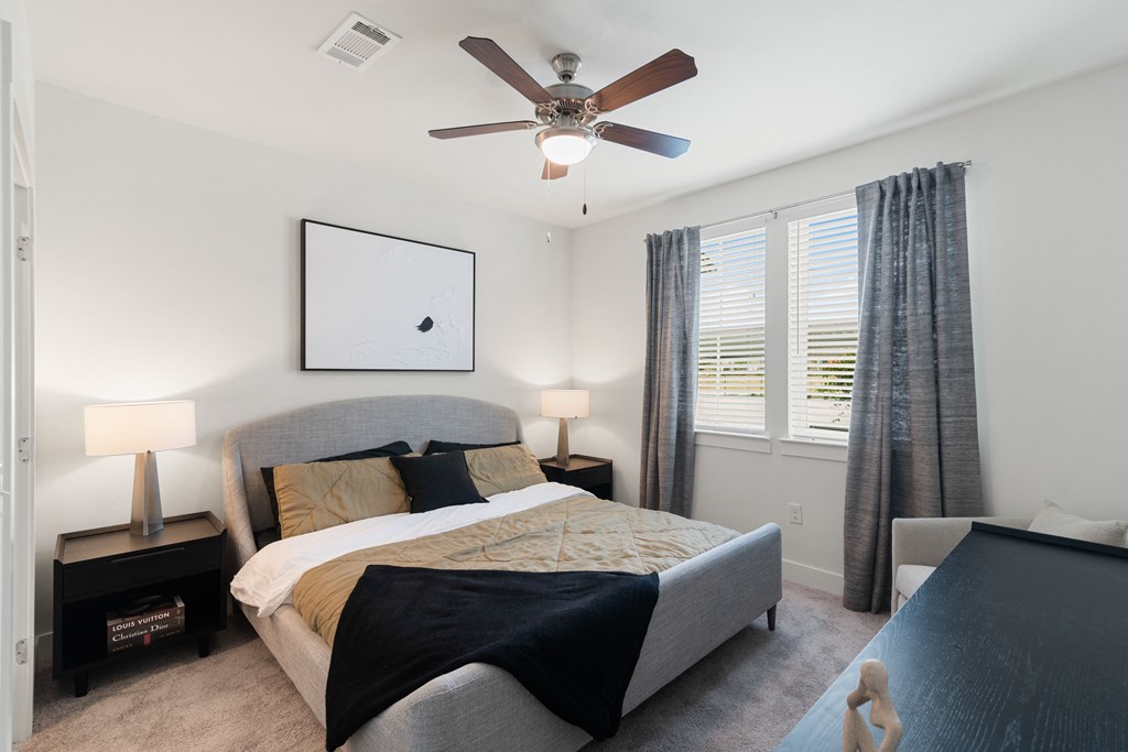 a bedroom with a large bed and a ceiling fan