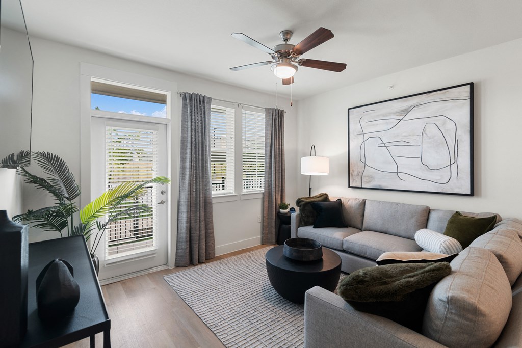 a living room with a couch and a ceiling fan