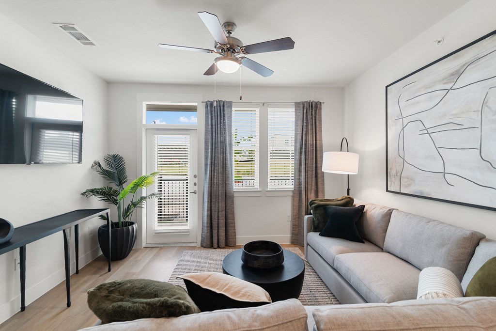 a living room with a couch and a ceiling fan