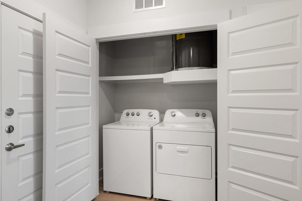 a white washer and dryer in a laundry room with white doors