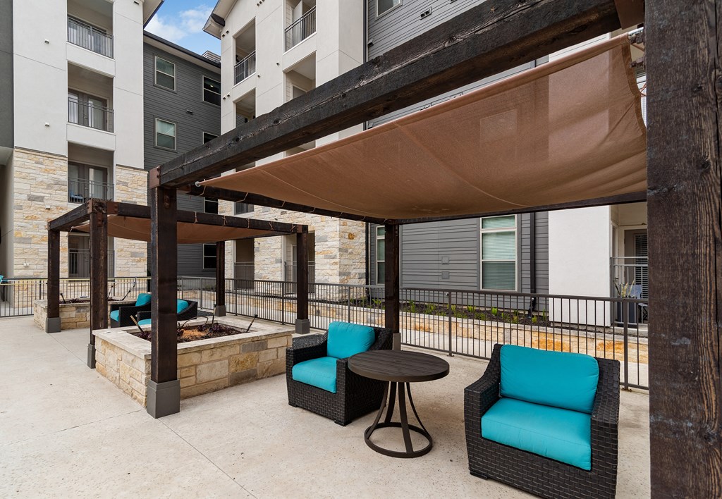 our patio has a fire pit and seating area with blue chairs and a table