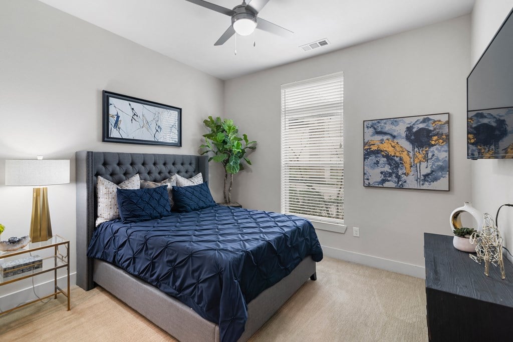 a bedroom with a bed and a ceiling fan